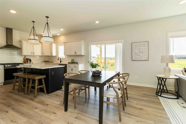 dining area with sink and light hardwood / wood-style floors