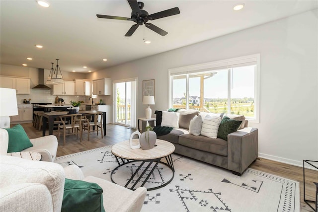 living room featuring ceiling fan and light hardwood / wood-style flooring