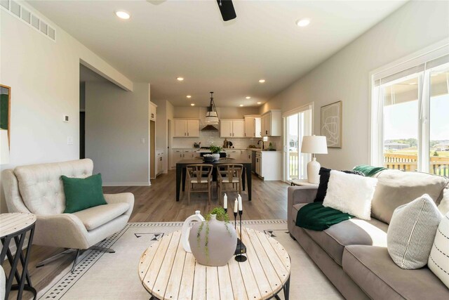 living area with visible vents, recessed lighting, and light wood-type flooring