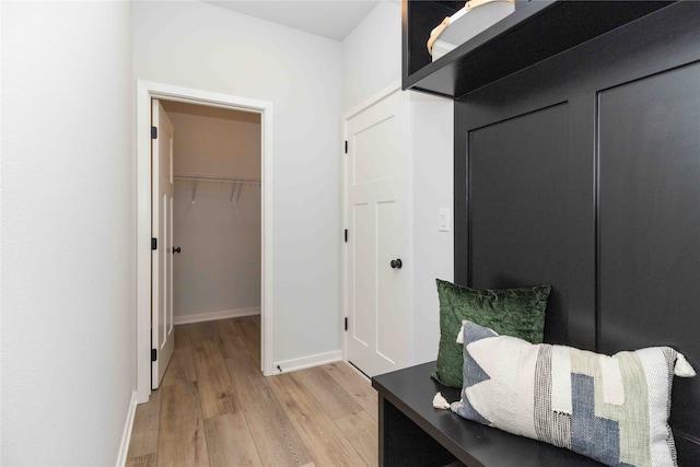 hall with baseboards and light wood-style flooring