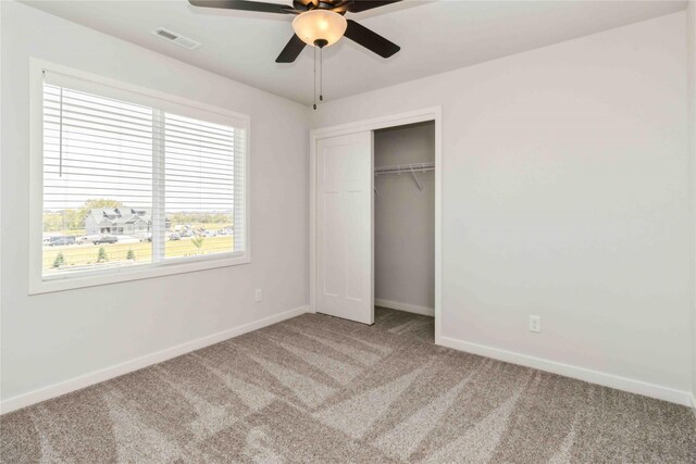 unfurnished bedroom with ceiling fan, carpet flooring, and a closet