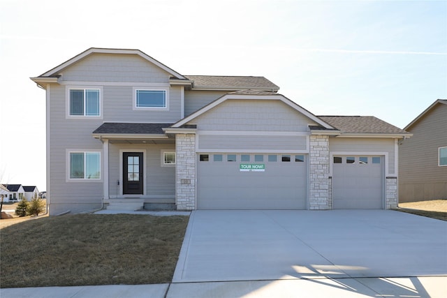 view of front facade featuring concrete driveway, a front yard, roof with shingles, stone siding, and an attached garage