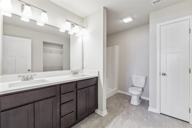 bathroom featuring walk in shower, vanity, and toilet