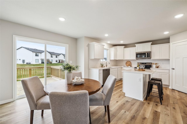 dining space with sink and light hardwood / wood-style floors