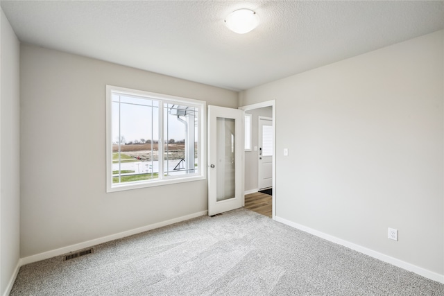 unfurnished bedroom with carpet floors and a textured ceiling