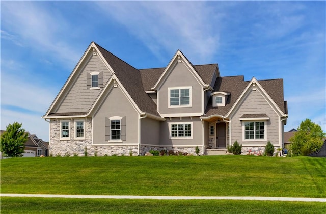 craftsman inspired home with a front yard, stone siding, and stucco siding