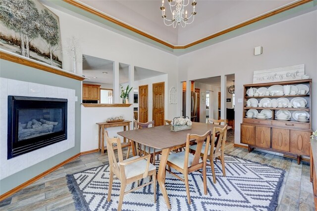 dining room featuring a healthy amount of sunlight, a chandelier, light hardwood / wood-style floors, and a fireplace