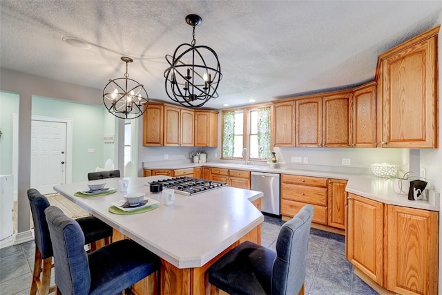 kitchen featuring hanging light fixtures, a breakfast bar, stainless steel appliances, a center island, and a chandelier