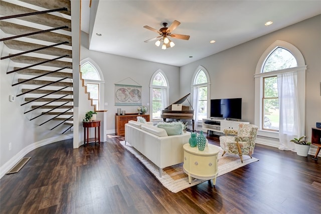 living room featuring ceiling fan, plenty of natural light, and dark wood-type flooring