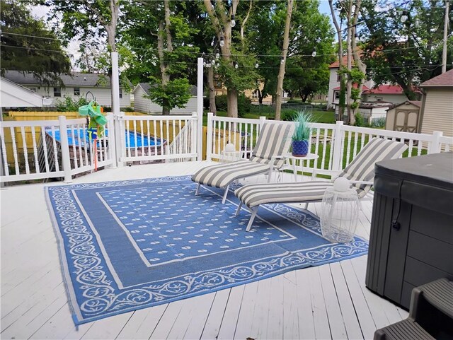 wooden terrace featuring a storage unit and a patio area