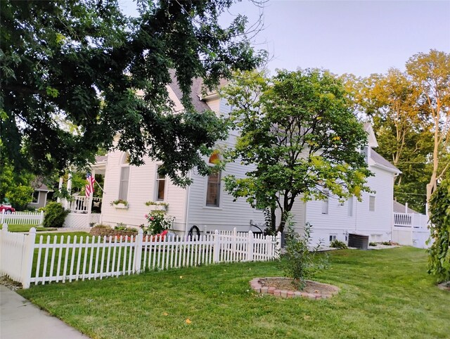 view of home's exterior with a yard and central AC