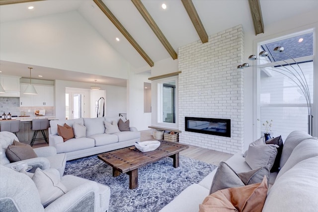 living room with a brick fireplace, high vaulted ceiling, beam ceiling, and light hardwood / wood-style flooring