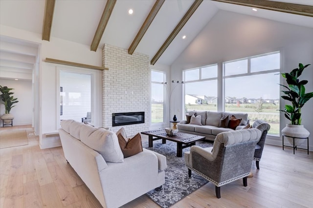 living room featuring a brick fireplace, light hardwood / wood-style floors, high vaulted ceiling, and beamed ceiling