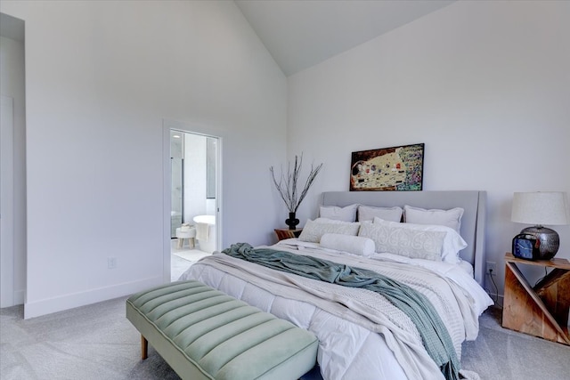 bedroom with high vaulted ceiling, connected bathroom, and light carpet