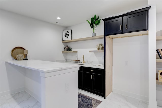 kitchen with kitchen peninsula and light stone counters