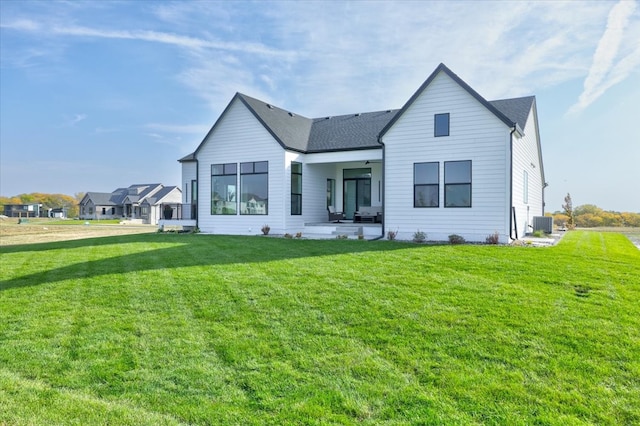 back of house featuring a lawn and a patio area