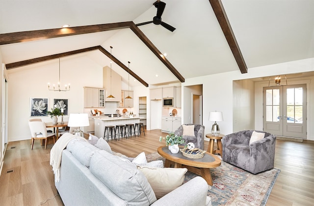 living room featuring ceiling fan with notable chandelier, beam ceiling, light hardwood / wood-style floors, and high vaulted ceiling