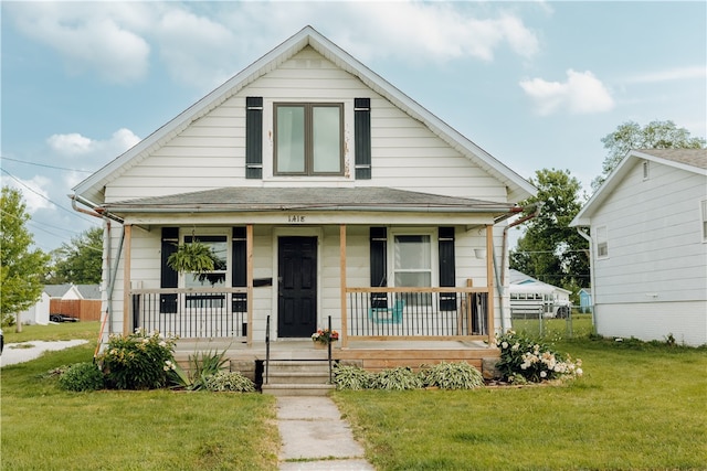 bungalow-style house with a front lawn and covered porch