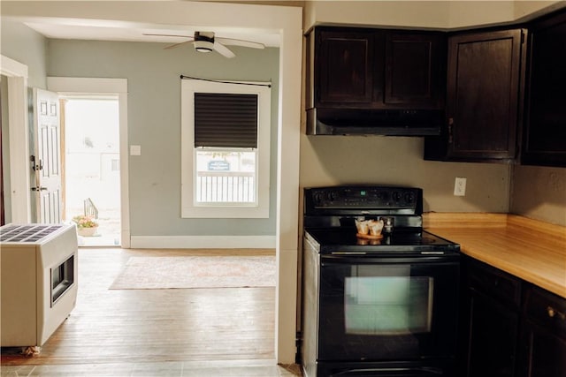 kitchen with black range with electric stovetop, under cabinet range hood, ceiling fan, heating unit, and light countertops