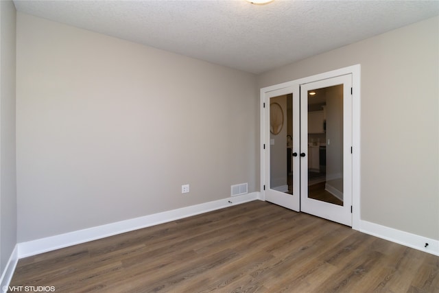 unfurnished room with dark hardwood / wood-style floors and a textured ceiling