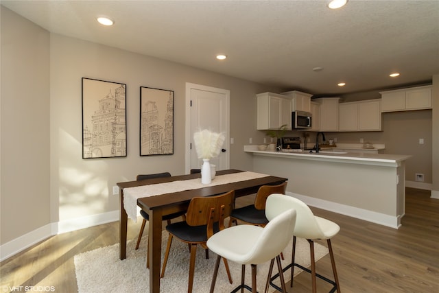 dining space featuring light wood-type flooring and sink