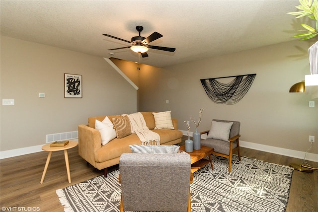 living room featuring hardwood / wood-style floors, ceiling fan, and a textured ceiling