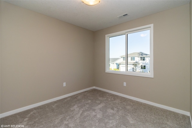 carpeted spare room featuring a textured ceiling