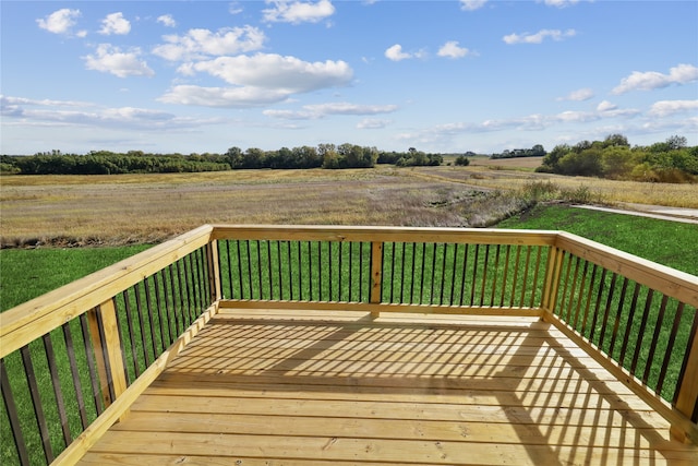 deck with a rural view and a yard