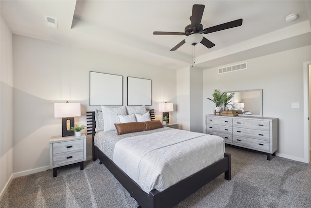 carpeted bedroom with ceiling fan and a raised ceiling