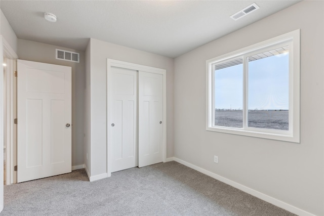 unfurnished bedroom featuring a closet and light carpet