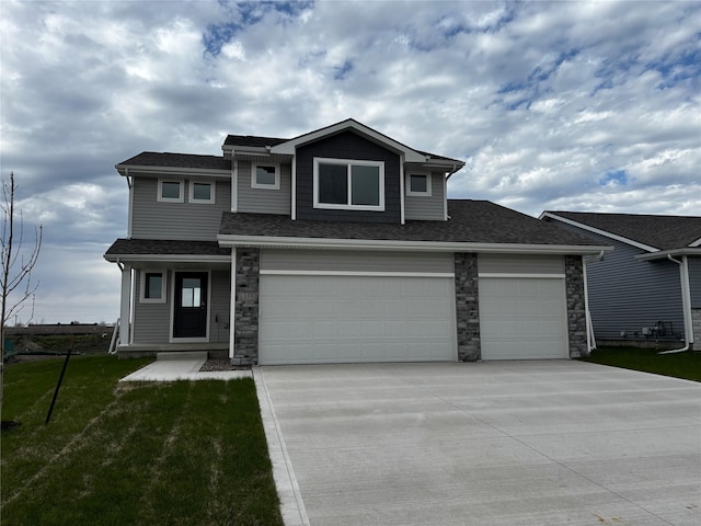 view of front of property with concrete driveway, a front lawn, roof with shingles, and stone siding