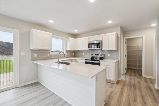 1355 Locust St, Waukee, IA 50263 - kitchen featuring stainless steel appliances, a sink, light countertops, white cabinets, and recessed lighting