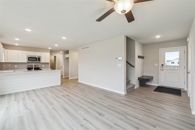 1355 Locust St, Waukee, IA 50263 - unfurnished living room featuring baseboards, light wood finished floors, stairs, recessed lighting, and a ceiling fan