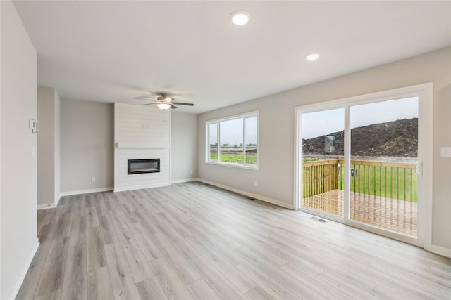 1355 Locust St, Waukee, IA 50263 - unfurnished living room featuring a ceiling fan, light wood-style floors, baseboards, a fireplace, and recessed lighting
