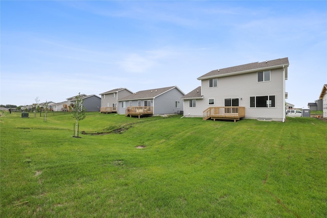 1355 Locust St, Waukee, IA 50263 - rear view of house featuring a wooden deck, a yard, and a residential view
