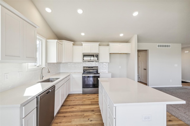 kitchen featuring visible vents, appliances with stainless steel finishes, decorative backsplash, and a sink