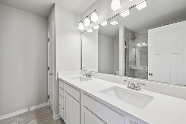 full bath featuring baseboards, toilet, a stall shower, and a sink
