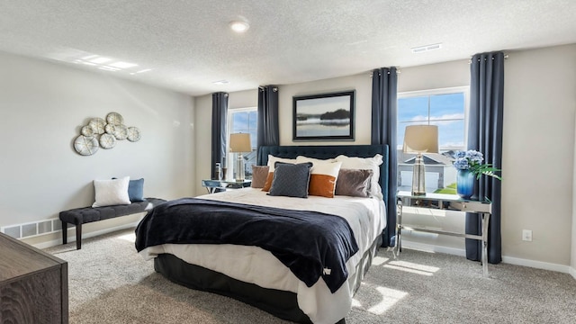 bedroom featuring a textured ceiling and light carpet