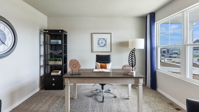 carpeted office with a textured ceiling