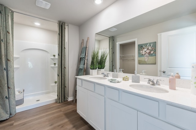 bathroom with vanity, wood-type flooring, and walk in shower