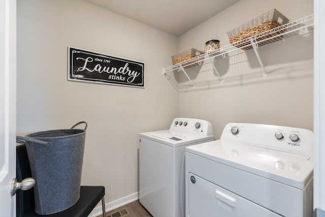 clothes washing area with dark hardwood / wood-style floors and washing machine and clothes dryer