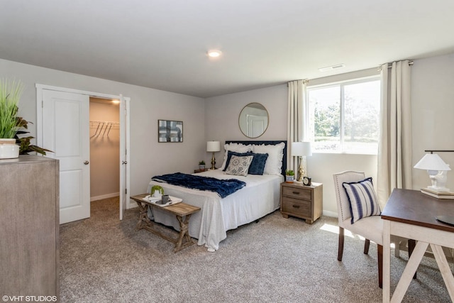 bedroom featuring light colored carpet, a spacious closet, and a closet