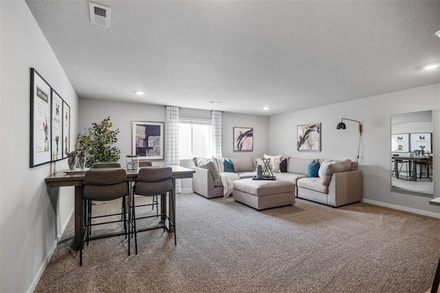 living room featuring carpet and a textured ceiling