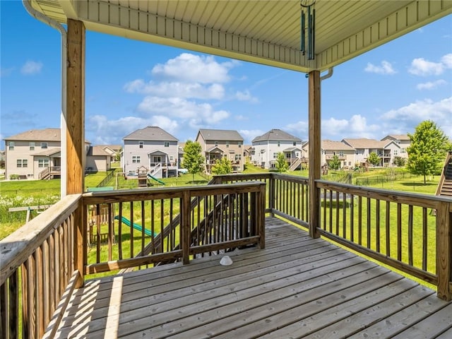 wooden terrace featuring a lawn