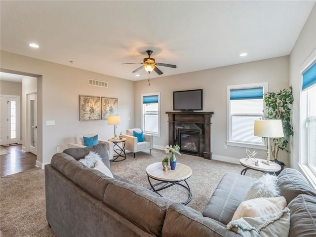 carpeted living room with ceiling fan