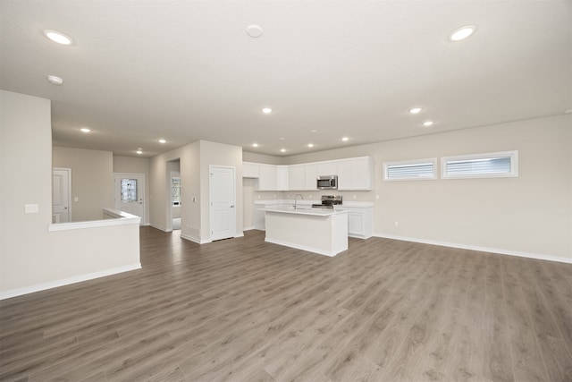 unfurnished living room featuring sink and light hardwood / wood-style flooring