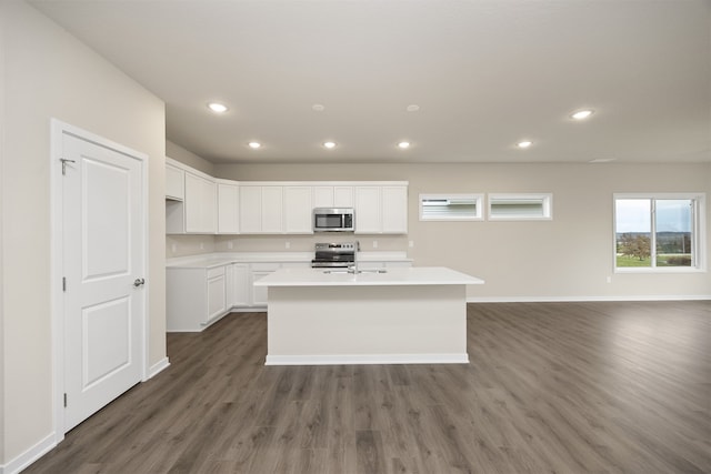 kitchen featuring sink, stainless steel appliances, dark hardwood / wood-style floors, a center island with sink, and white cabinets