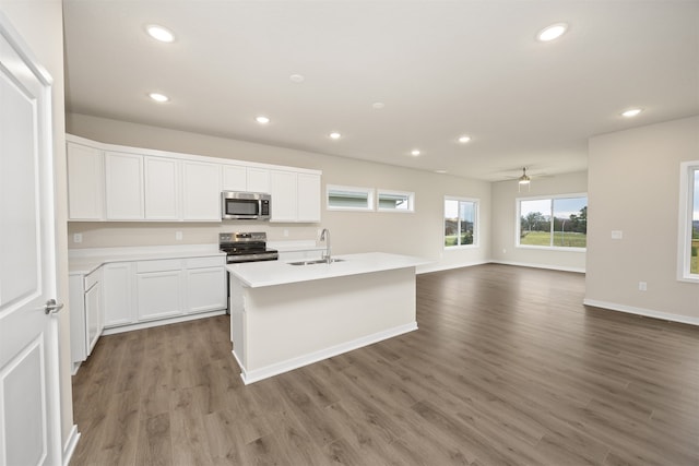 kitchen featuring a center island with sink, sink, dark hardwood / wood-style flooring, white cabinetry, and stainless steel appliances