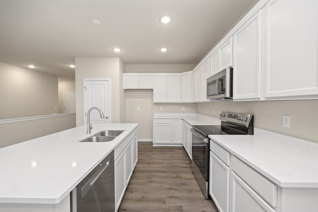 kitchen featuring appliances with stainless steel finishes, sink, a center island with sink, light hardwood / wood-style floors, and white cabinetry