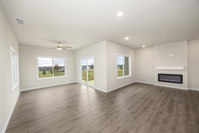 unfurnished living room with dark hardwood / wood-style floors and ceiling fan